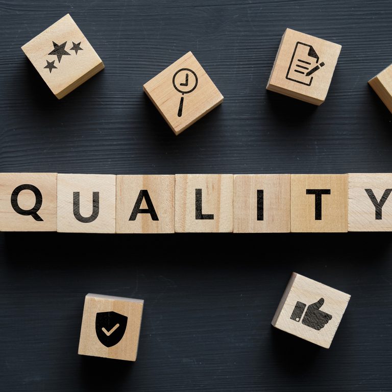 Quality concept with themed icons on wooden cubes
