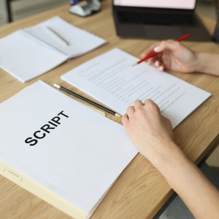 Actress checks script papers for filming movie making notes with pencil. Woman edits text at wooden table in office and prepares for playing role