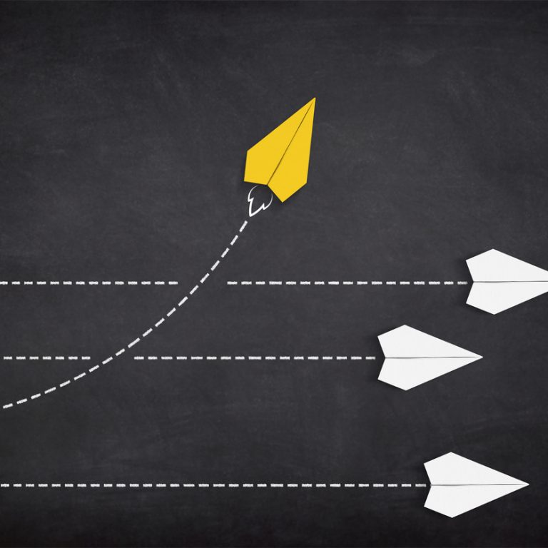 Yellow paper plane coming out from the advancing white paper planes. Change and different way concept.