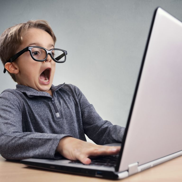 Shocked and surprised boy on the internet with laptop computer concept for amazement, astonishment, making a mistake, stunned and speechless or seeing something he shouldn't see